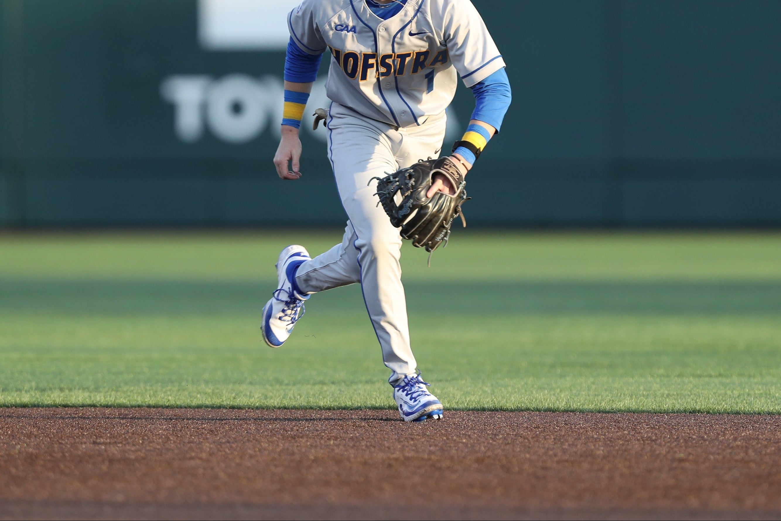 Baseball player in a gray uniform with blue accents on a baseball field