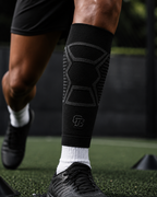 Person wearing a black compression sleeve on a sports field