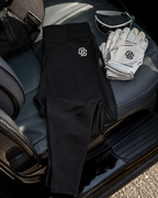 Black pants with a logo, white gloves, and sunglasses on a car seat