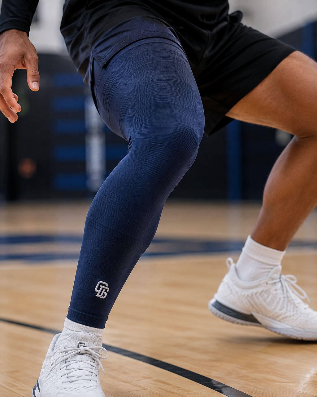 Person wearing navy leggings with a logo on a basketball court