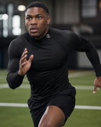 Person running on a track wearing a black athletic outfit with a brand logo.