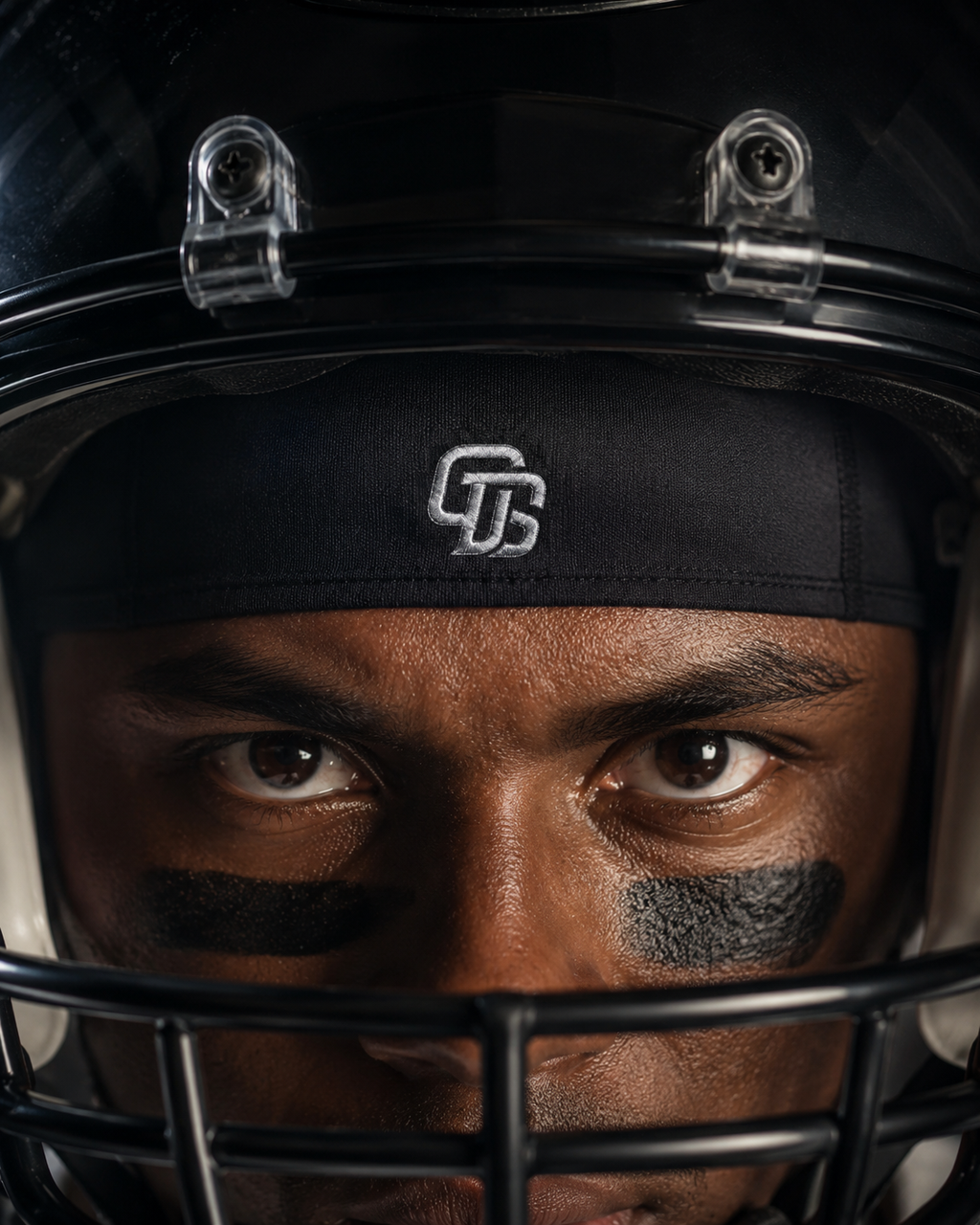 Person wearing a football helmet with a close-up of the face, featuring a logo on the headband.